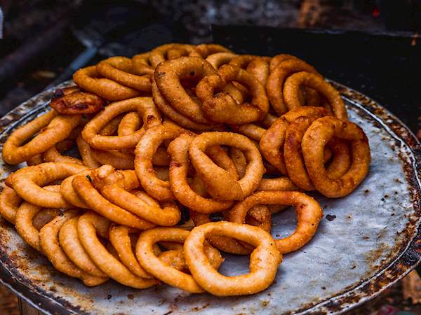 Golden, crispy Nepali Sel Roti served on a traditional plate, showcasing authentic Himalayan festival cuisine.