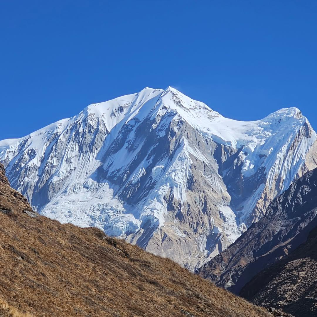 Stunning view of the snow-capped Himalaya during the Annapurna Base Camp trek, with rugged mountain peaks and clear blue sky showcasing the beauty of the Annapurna region treks.