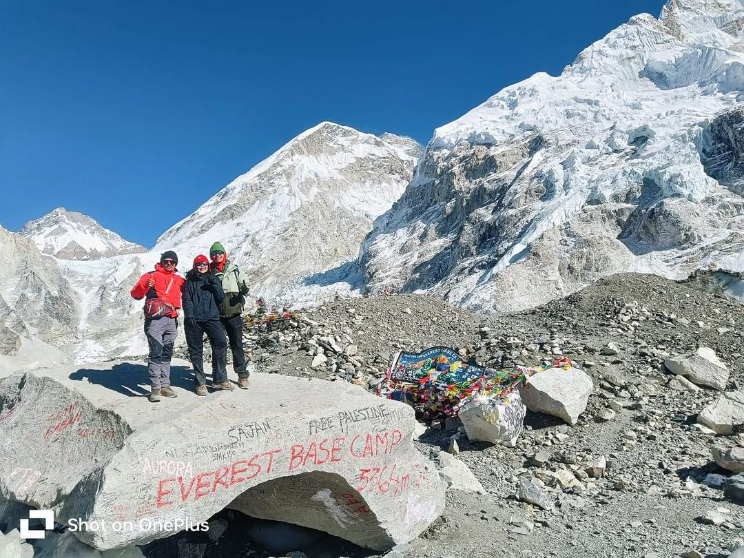 Thrilled trekkers celebrating upon successfully reaching Everest Base Camp, surrounded by majestic snow-covered peaks and prayer flags, highlighting the adventure of the Everest Base Camp trek.