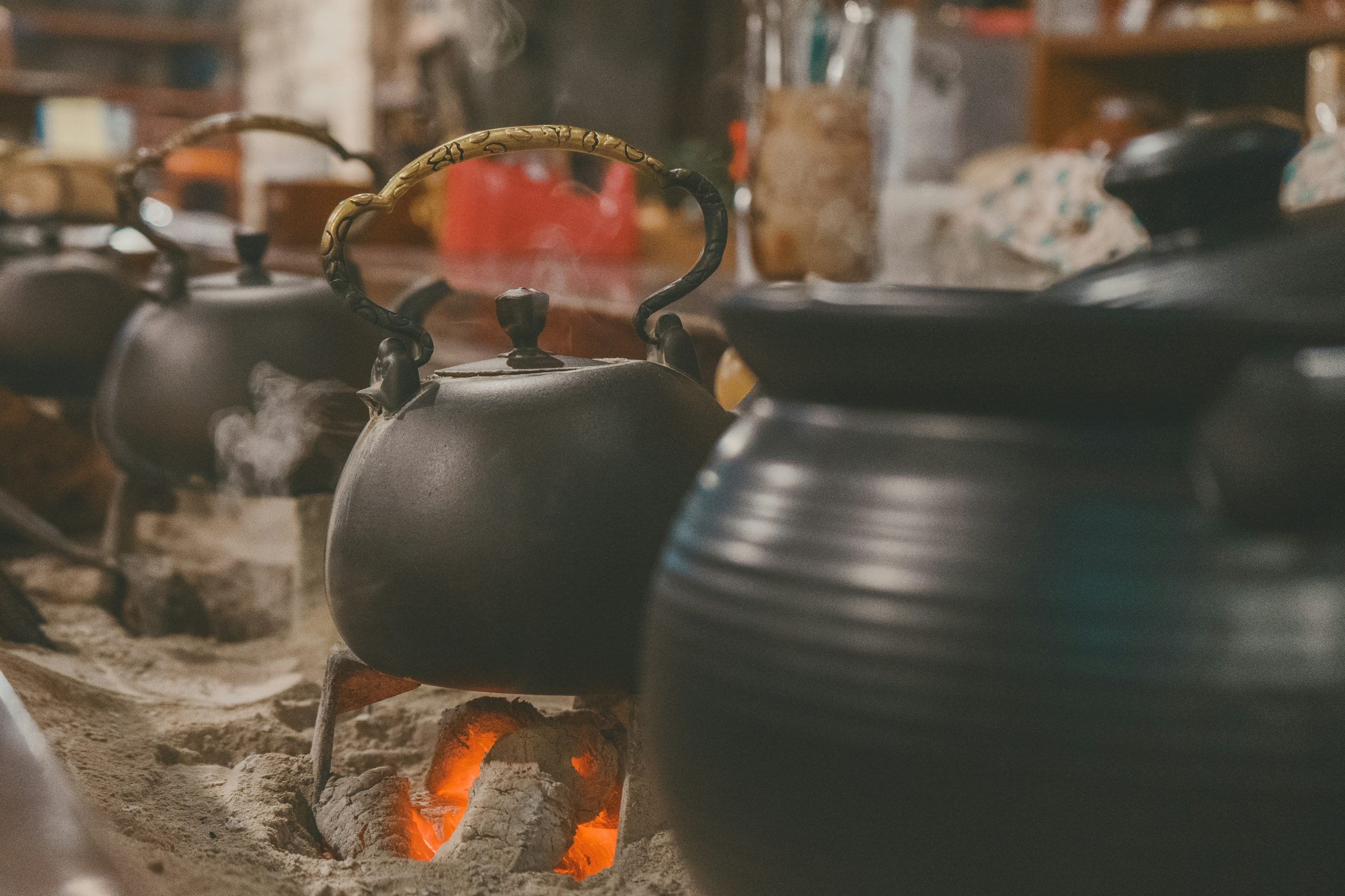 Teapots boiling over an open fire in a cozy teahouse, symbolizing the warmth and hospitality of teahouse trekking in Nepal.