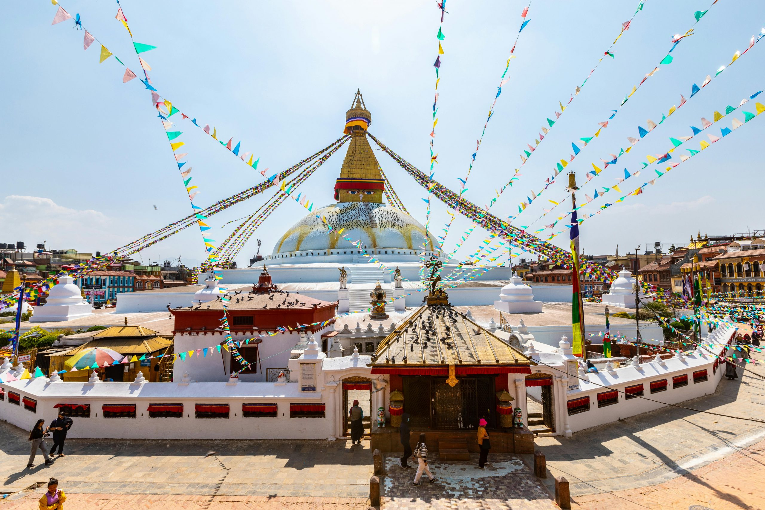 Boudhanath Stupa, one of the largest in the world, with its striking mandala design, surrounded by prayer wheels and bustling streets, located in Kathmandu, Nepal.